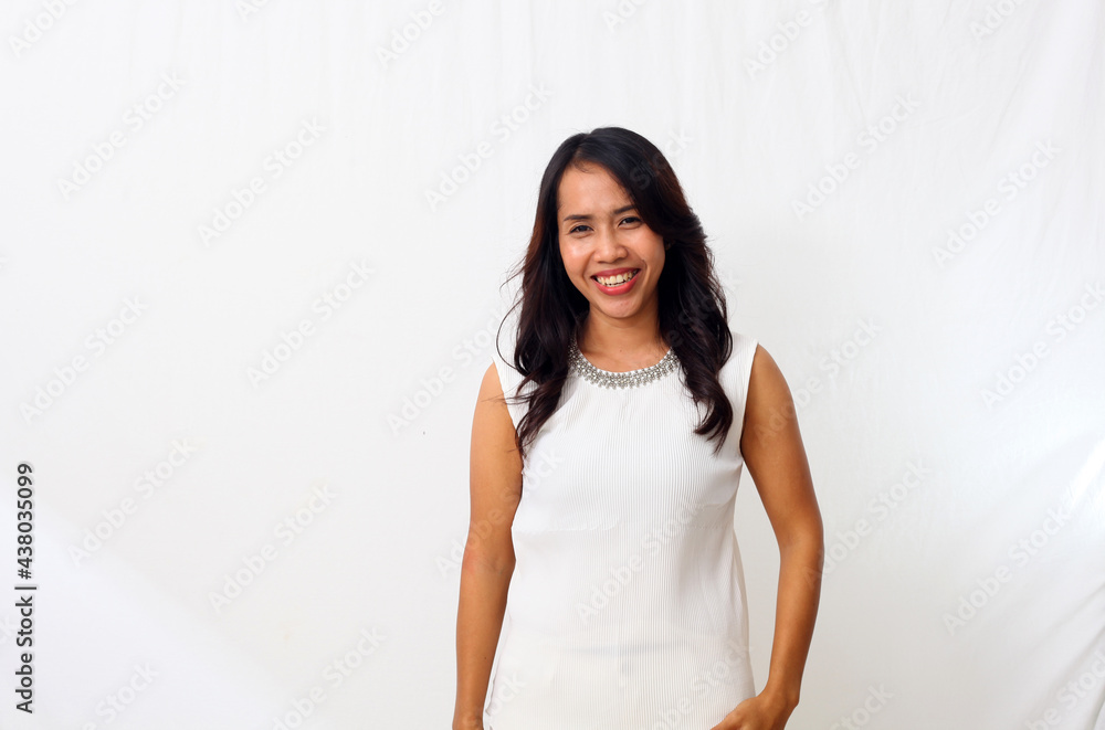 Portrait of happy young asian woman smiling against white wall Portrait of happy young asian woman smiling against white wall