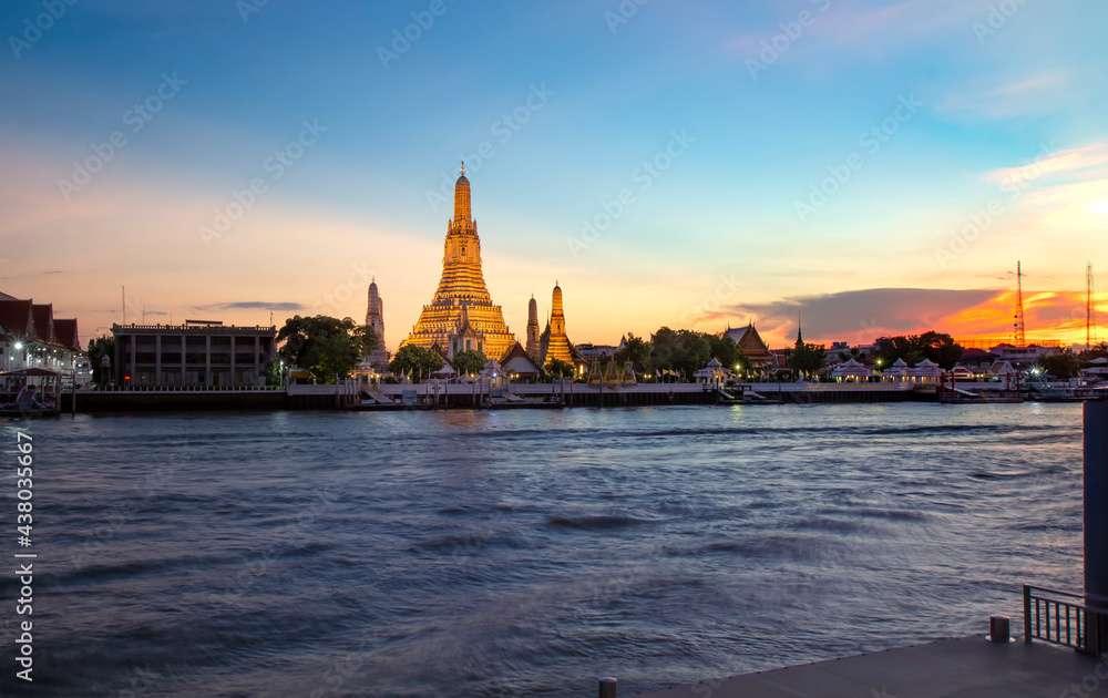 View of beautiful Wat Arun Rajvararam or Wat Arun or Wat Makok at waterfront of the Chao Phraya River in twilight,Which is historical significance and famous tourist destination of Bangkok,Thailand.