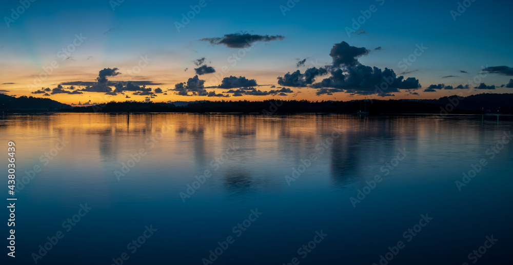 Blue hour bay waterscape with scattered clouds