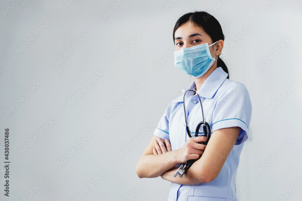 A young nurse with arms folded And holding a stethoscope A young nurse with arms folded And holding a stethoscope