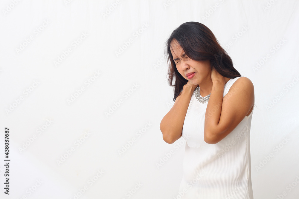 Beautiful asian girl standing while holding and feeling pain in her shoulder. Isolated on white background with copyspace Beautiful asian girl standing while holding and feeling pain in her shoulder. Isolated on white background with copyspace