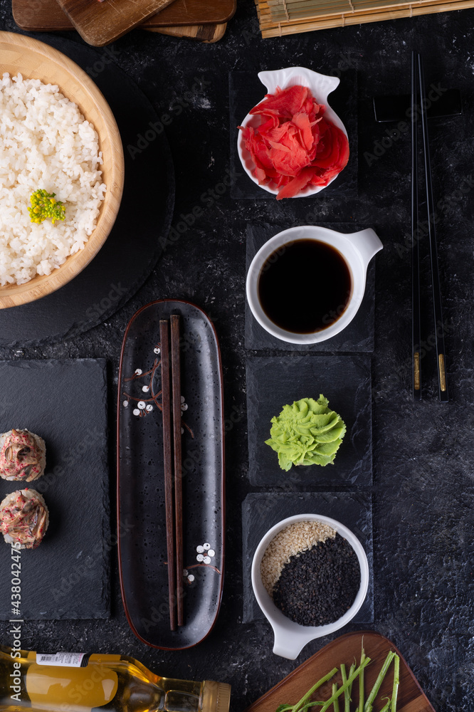  set for  sushi   served  at black dish at black table. flat lay