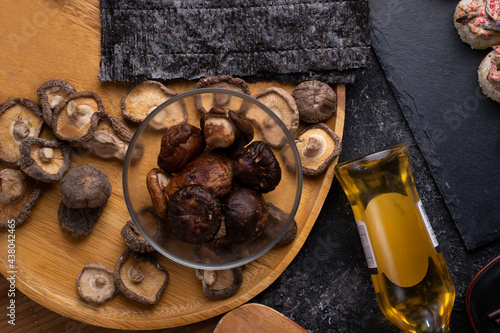  set for cooking sushi roll with shiitake mushrooms with rice served  at gblack dish at black table. flat lay photo