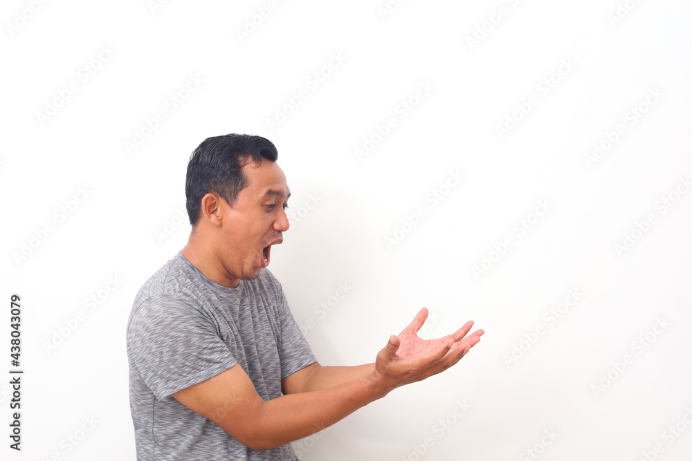 Wow and shocked face of Asian man point to present an empty space of content. Advertising model concept. Wow and shocked face of Asian man point to present an empty space of content. Advertising model concept.