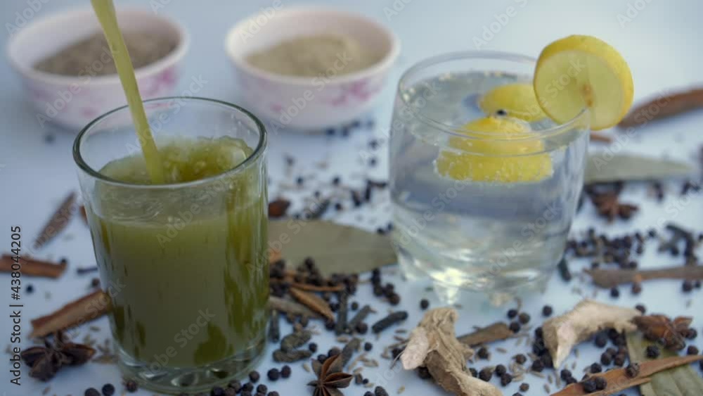 Refreshing Jaljeera drink with fresh mint leaves and Boondi pouring in a clear glass. Famous Indian spices like cinnamon  cloves  black pepper  and bay leave together with a soda carbonated water