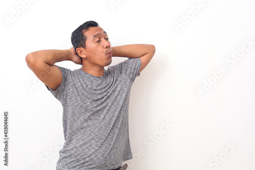 Portrait of Asian man standing while relax and whistling. Isolated on white background with copyspace