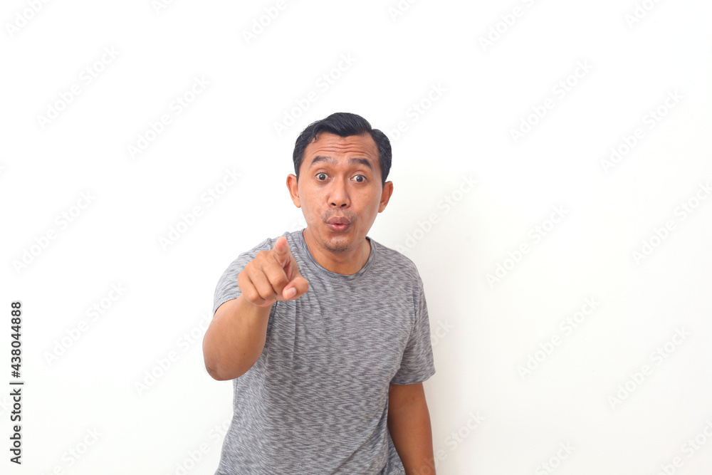 Asian man wearing casual clothes pointing displeased and frustrated to the camera, angry and furious with you. Isolated on white background Asian man wearing casual clothes pointing displeased and frustrated to the camera, angry and furious with you. Isolated on white background