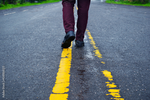 Walking way wearing black leather shoes and brown trouser.