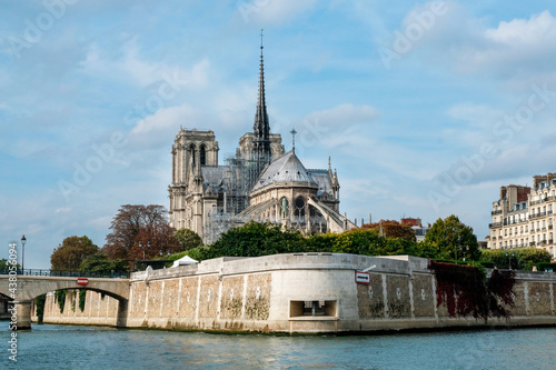 Paris, France - Oct 15, 2018: Exterior view from Seine river of Notre-Dame Cathedral, French Gothic architecture in Paris. In roof maintenance period.