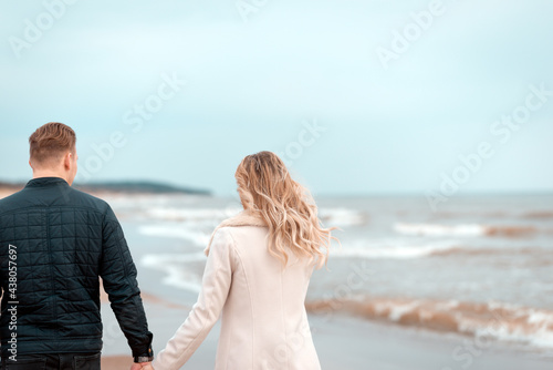 Loving couple relaxing on sandy beach. Love concept.Back view.Spring,autumn vacation.