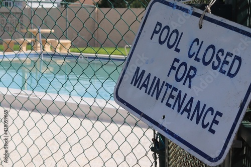 'Pool Closed for Maintenance' Sign with Pool in Background