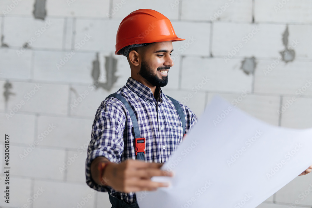 repair, construction and building concept - happy smiling male worker or builder in helmet with blueprint over empty room at new home on background repair, construction and building concept - happy smiling male worker or builder in helmet with blueprint over empty room at new home on background