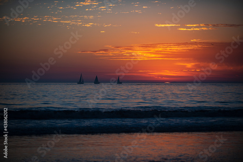 Calm sea with sunset sky and sun through the clouds over. Ocean and sky background, seascape.