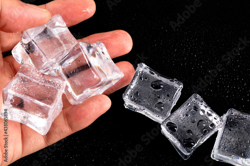 Ice cubes with water drops in hand