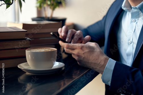 man with a phone in his hands sitting in a cafe leisure work lifestyle businessman