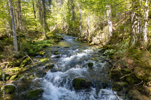 Wunderschöner Gebirgsfluss in den Alpen mit Panorama und kleinen Wasserfällen