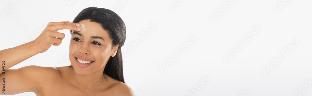 smiling young african american woman applying cream on forehead on white background, banner smiling young african american woman applying cream on forehead on white background, banner