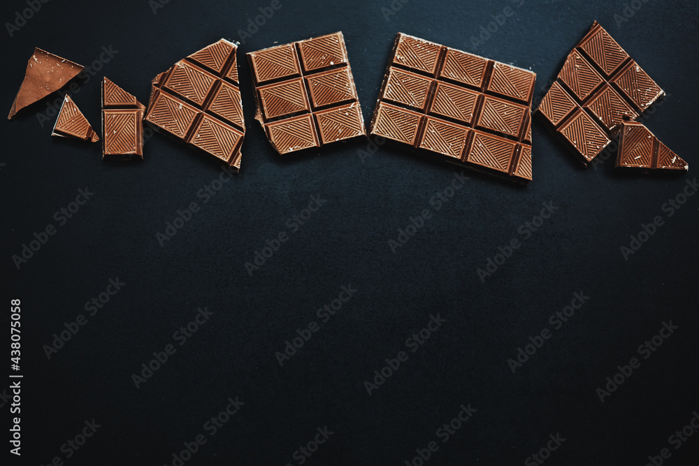 Obraz premium Chocolate bars broken on dark background