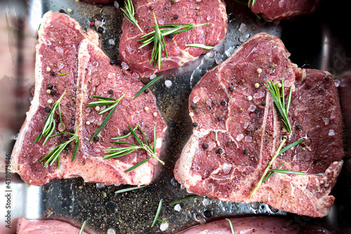 T bone steak raw veal meat. Aged angus tbone beef for barbeque with salt and rosemary seasoning. Fresh beafsteak cut from butcher, prime gourmet black angus loin