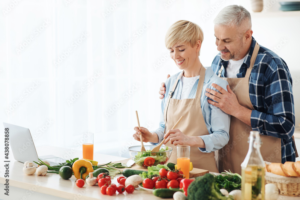 Senior couple bloggers recording video content, preparing healthy food in kitchen Senior couple bloggers recording video content, preparing healthy food in kitchen