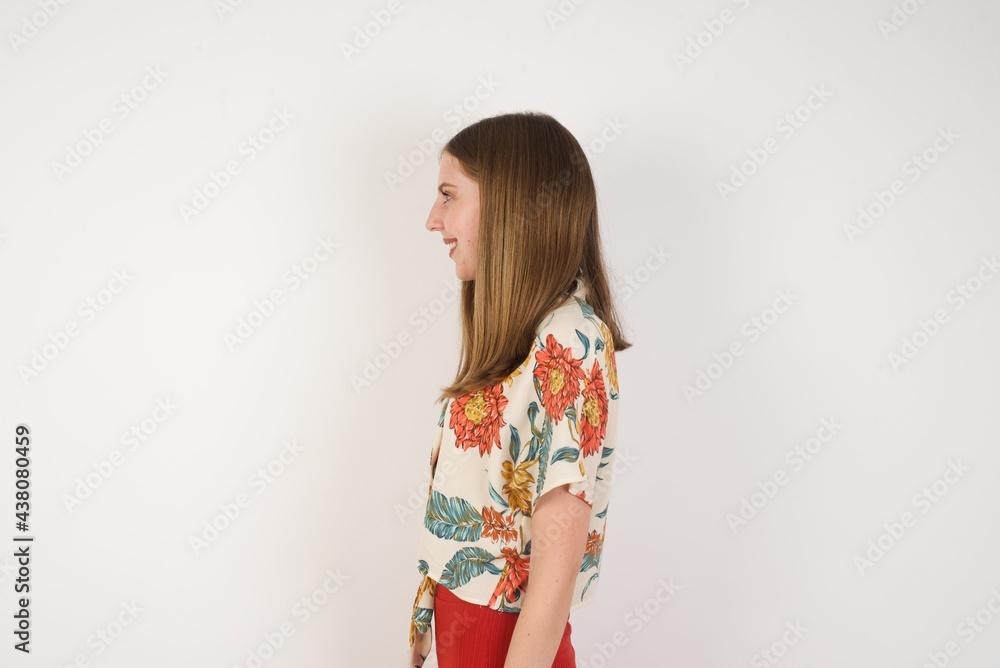 Profile of smiling woman with healthy pure skin, has contemplative expression, ready to have outdoor walk, isolated over white studio wall with copy space Profile of smiling woman with healthy pure skin, has contemplative expression, ready to have outdoor walk, isolated over white studio wall with copy space