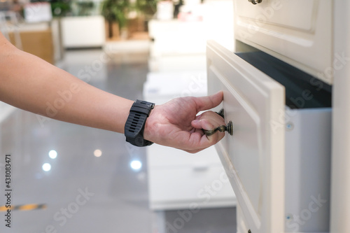 man open shelf, pull open drawer wooden in cabinet.