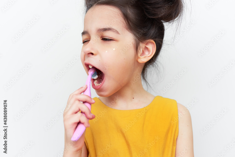 Portrait of a little girl brushing teeth, isolated on grey studio background. Pretty child ready to brush his teeth. Dentist day, teeth care, and healthcare concept. Portrait of a little girl brushing teeth, isolated on grey studio background. Pretty child ready to brush his teeth. Dentist day, teeth care, and healthcare concept.