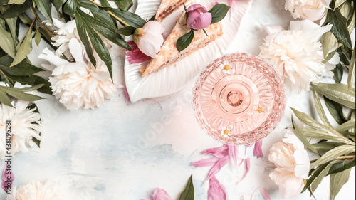 Fototapeta Naklejka Na Ścianę i Meble -  Rose wine glasses, pieces of sweet cake with peonies flowers on white background, top view. Summer drink for party, wine shop or wine tasting concept. banner, menu recipe place for text, top view