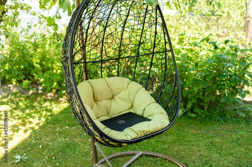 Coccoon chair in the garden. Green nature and comfy sitting place. photo