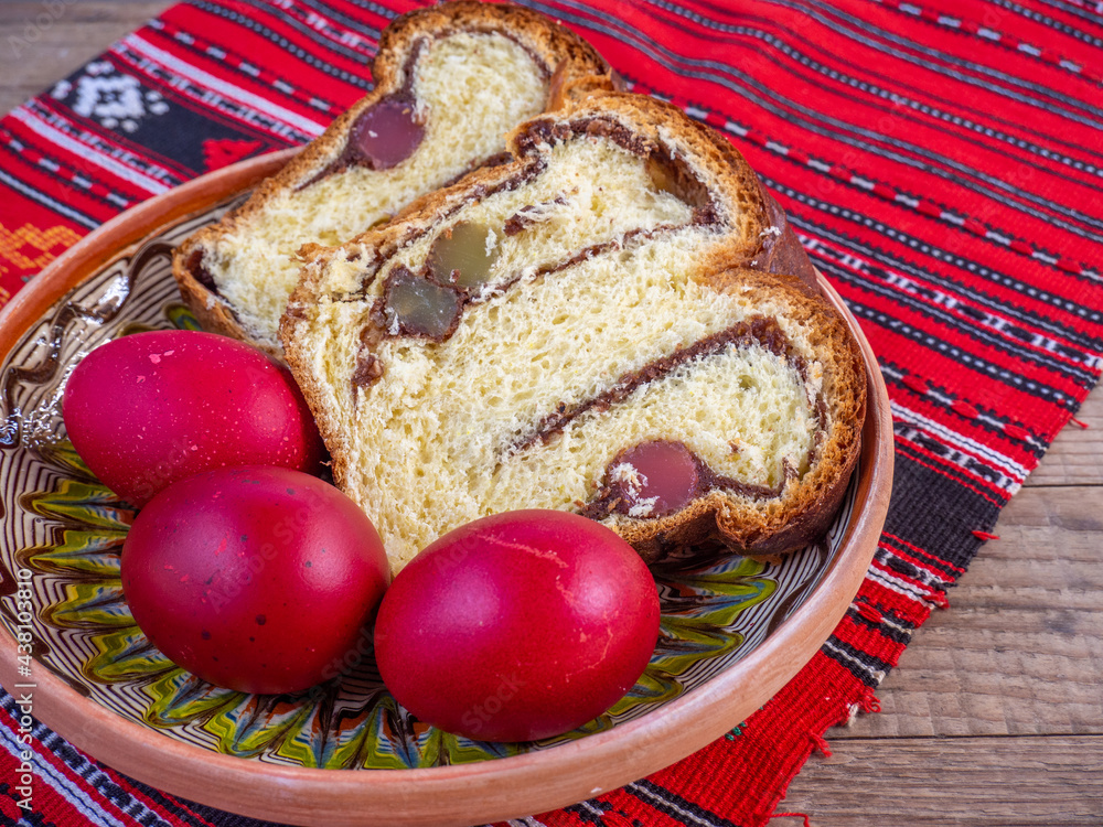 Fotografie orthodox easter eggs and sponge cake on traditional cloth