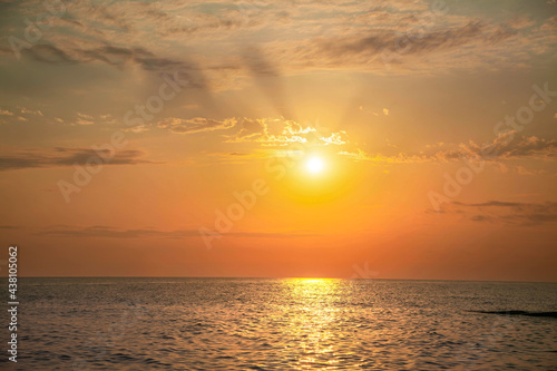 beautiful orange sunset over the sea with clouds and calm water