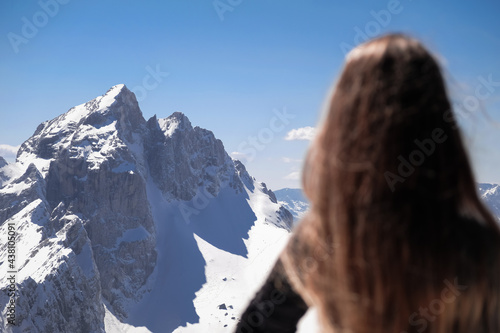 smiling woman climber in snowy mountains with ice ax