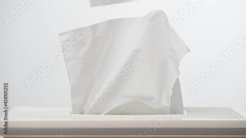 a person's hand pull out a piece of tissue from white tissue paper box isolated on white background. Healthcare concept.