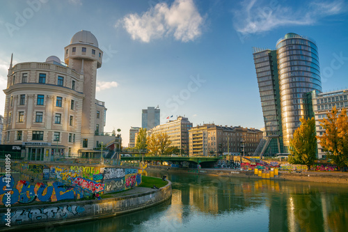 vienna, austria - OCT 17, 2019: architecture on donaukanal at sunset. water way betweein famous buildings of urania observatory and uniqa tower in evening light. popular travel destination in autumn photo