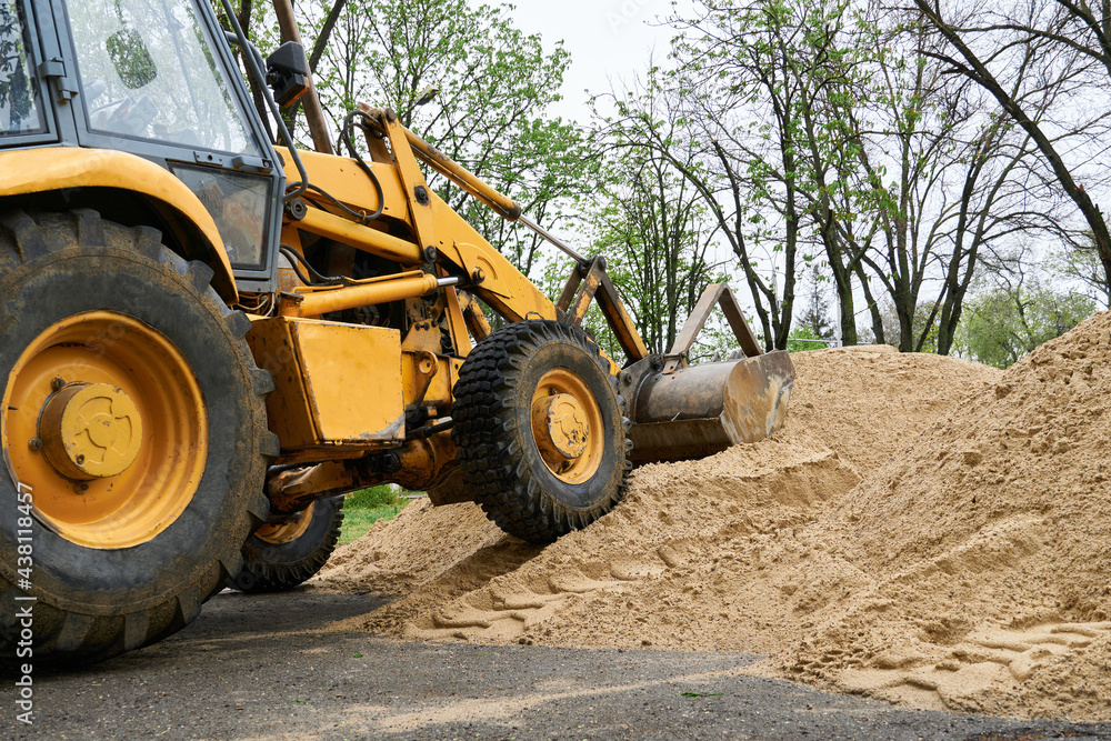 tractor or bulldozer works with a pile of sand for construction tractor or bulldozer works with a pile of sand for construction
