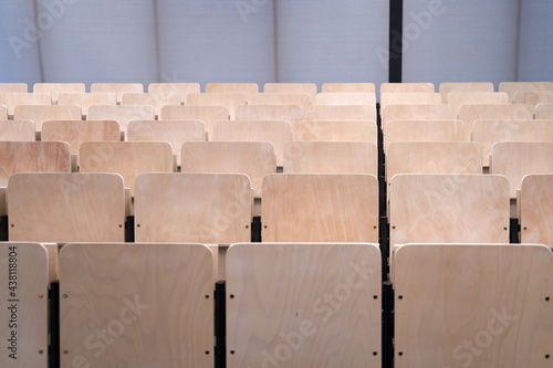 Empty collapsible wooden chairs in auditorium background. Higher education at university or college.