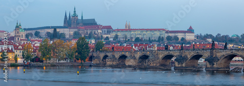 Prague - The panorama of Charles Bridge, Castle and Cathedral from promenade over the  Vltava river at dusk.