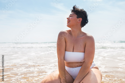 Lady sitting on sandy coast near sea