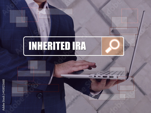  INHERITED IRA Individual Retirement Accounts inscription on the screen. Close up Merchant hands holding black smart phone.