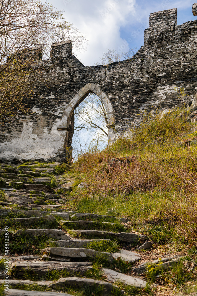Road to medieval gothic castle Bezdez, grey stone ruin on hill at sunny day, ancient fortress walls, fairytale stronghold, arched portal, entrance gate, North Bohemia, Czech Republic