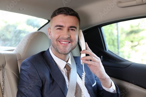 Retro businessman using telephone with cord in limousine  © ajr_images