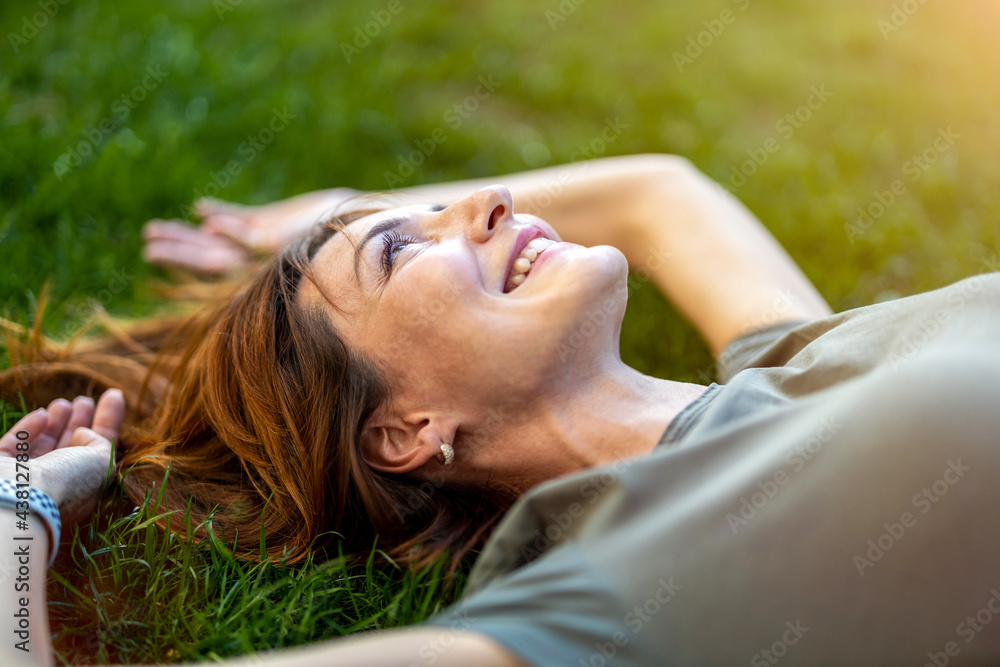 Carefree woman lying on the grass in the sun
Carefree woman lying on the grass in the sun