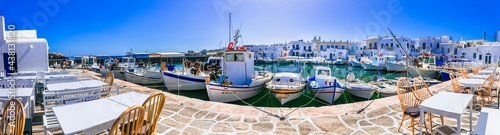 Greece travel. Cyclades, Paros island. Charming fishing village Naoussa. view of old port with  boats and restaurants (taverns) by the sea. may 2021 photo