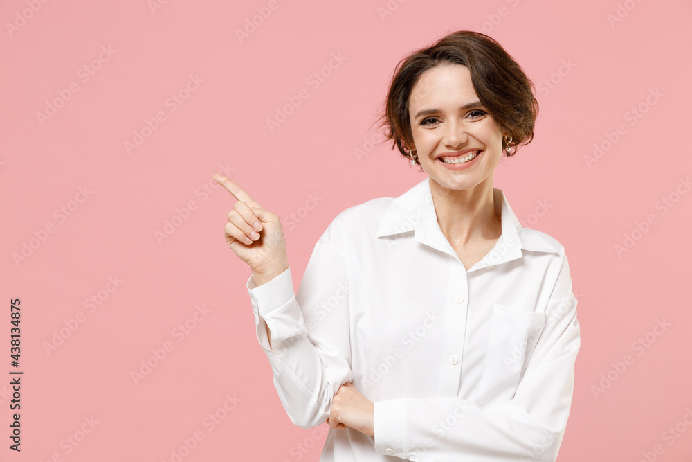 Young smiling employee business woman corporate lawyer in classic formal white shirt work in office point index finger aside on workspace area mock up copy space isolated on pastel pink background Young smiling employee business woman corporate lawyer in classic formal white shirt work in office point index finger aside on workspace area mock up copy space isolated on pastel pink background