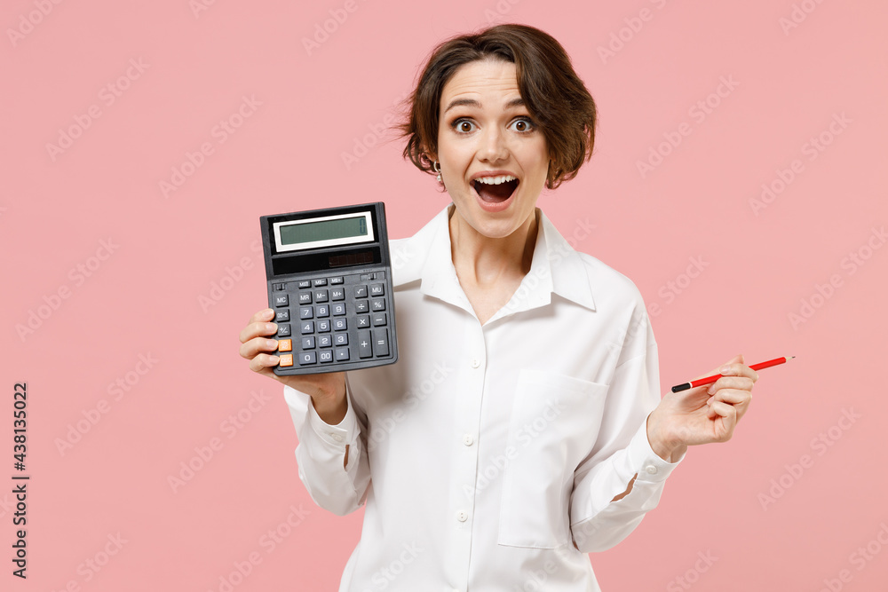 Young smiling successful employee business secretary woman corporate lawyer in classic formal white shirt work in office hold in hands calculator isolated on pastel pink background studio portrait - obrazy, fototapety, plakaty 