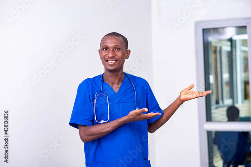 young male doctor pointing hands aside smiling.