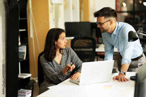 Colleagues in office. Businesswoman and businessman discussing work in office.