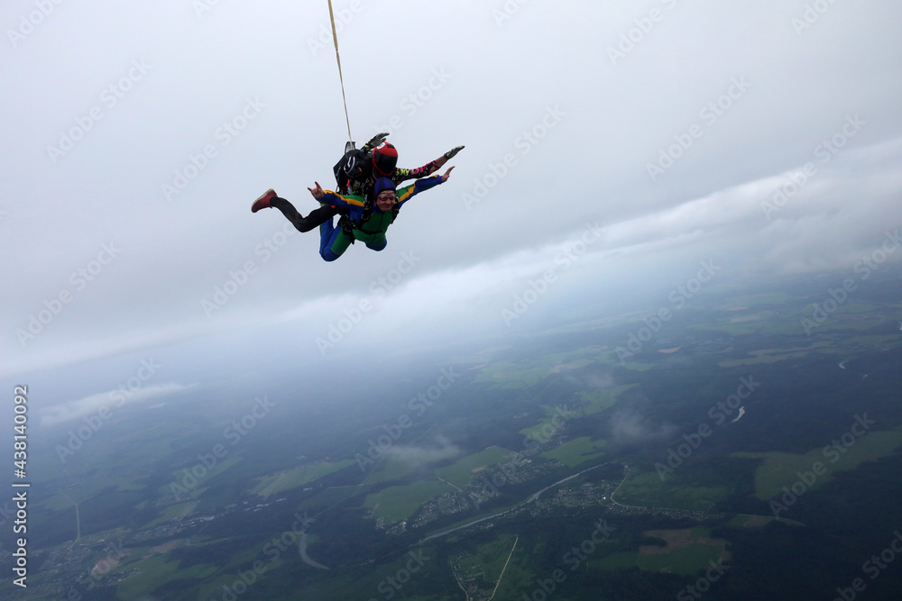 Fototapeta premium Skydiving. Tandem jump is in the cloudy sky.