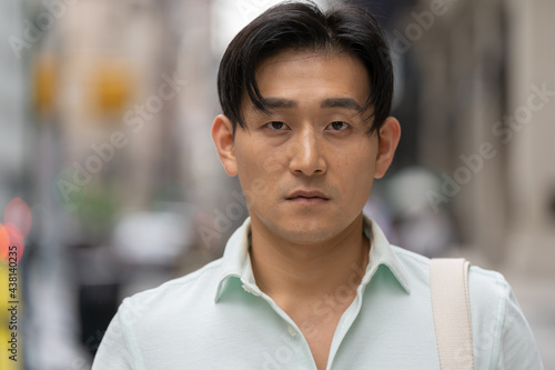 Young Asian man in city serious face portrait