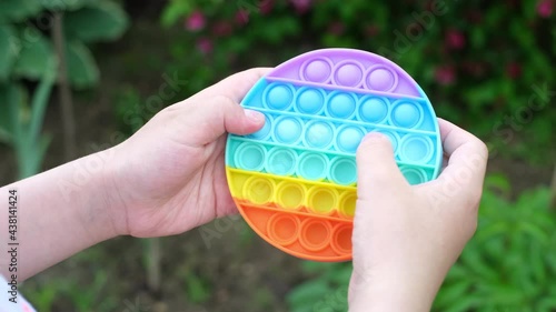 New popular silicone popit toy, baby is playing with it. Rainbow Trendy Pop it fidget toy
